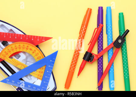 Mehrfarbige Herrscher und Stift auf gelbem Hintergrund Stockfoto