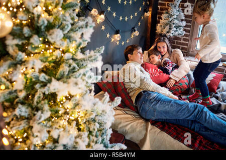 Mutter und Vater mit Kindern zu Hause spielt, am Weihnachtstag Stockfoto