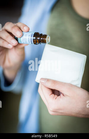 Frau Anwendung Lemongras ätherisches Öl auf einem Gewebe. Stockfoto