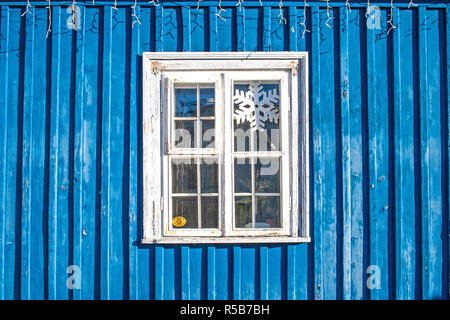 Alte weiße Holz- Fenster mit blauen Holzwand, Weihnachtsbeleuchtung und Schneeflocke Stockfoto