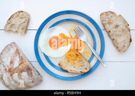 Gebratene Hühner Eier auf einem cornishware Platte mit Sauerteigbrot Stockfoto