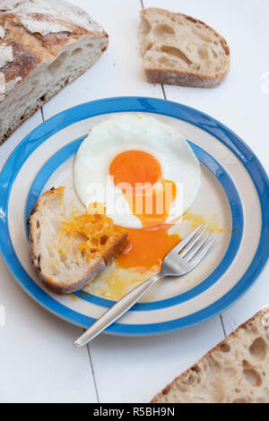 Gebratene Hühner Eier auf einem cornishware Platte mit Sauerteigbrot Stockfoto