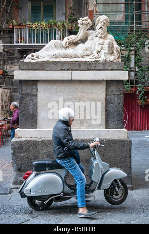 , 2. - 3. Jahrhundert N.CHR. Römische Statue des Gottes Nil blickt auf ein Mann Parkplatz seiner Vespa, in der Piazzetta Nilo auf der Spaccanapoli" Neapel Split Stockfoto