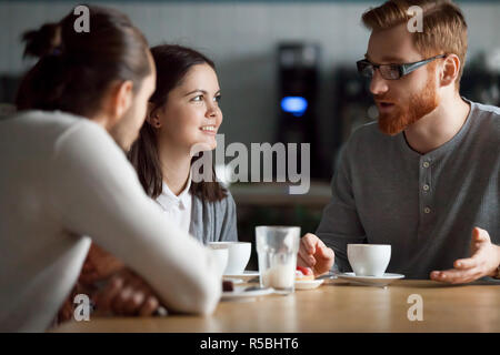 Diverse Freunde treffen im Coffeeshop im Gespräch am Tisch, glückliche Schüler haben Spaß im Cafe Kaffee genießen, Zeit miteinander zu verbringen, tausendjährigen Arbeitskollegen Stockfoto