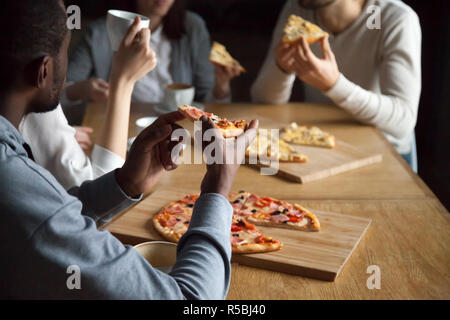 In der Nähe von diversen Freunden rumhängen in Pizzeria pizza und Kaffee, multiethnischen junge Leute sprechen Spaß im Italienischen Restaurant essen lecker f Stockfoto
