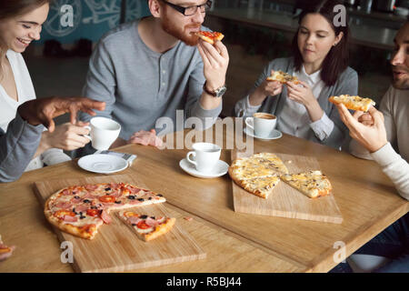 Multiethnischen Freunde Spaß im Italienischen Restaurant, essen Pizza und trinken Kaffee, verschiedenen Kollegen reden im Cafe Tisch, genießen Sie leckeres Essen, jungen p Stockfoto
