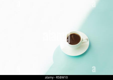 Tasse Kaffee auf türkis-blauen Tisch. Abstrakte Foto von heißem Espresso trinken auf hellblau-grünen Hintergrund. Stockfoto