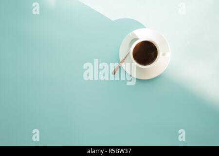 Tasse Kaffee auf Seafoam Green Tabelle, Ansicht von oben. Abstrakte Foto von heißem Espresso trinken auf hellblau-grünen Hintergrund. Stockfoto