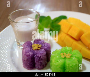 Geschlossen bis köstlichen Klebreis mit unscharfen Frische reife Mango und Kokosmilch im Hintergrund Stockfoto