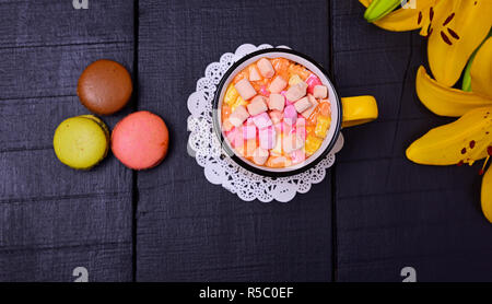 Heiße Schokolade mit Marshmallows auf einem schwarzen Hintergrund aus Holz, Ansicht von oben Stockfoto