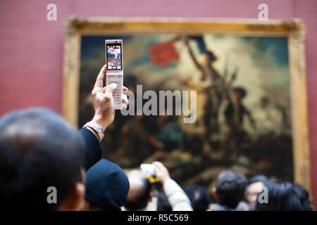 Frankreich, Paris, Musée du Louvre Museum, 19. Jahrhundert französische Malerei Galerie, Besucher fotografieren der Malerei die Freiheit führt das Volk von Delacroix Stockfoto