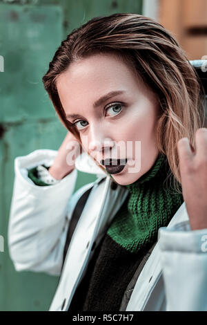 Grünäugige Modell. In der Nähe von Green-eyed Foto Modell mit schwarzen Lippen in weiss Winter Jacke posing Stockfoto