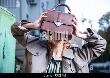 Ledertasche. Professionelle foto Modell mit leuchtend roten Lippen halten kleine Ledertasche von Neue Kollektion Stockfoto