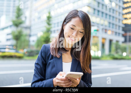 Geschäftsfrau Arbeiten am Handy in Tokyo City Stockfoto