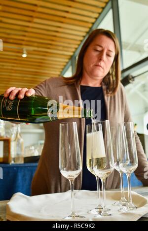 Frau gießen Champagner Sekt aus einer Flasche in Gläsern und in einer Bar Restaurant Rezeption in Eureka Springs, Kalifornien, USA. Stockfoto