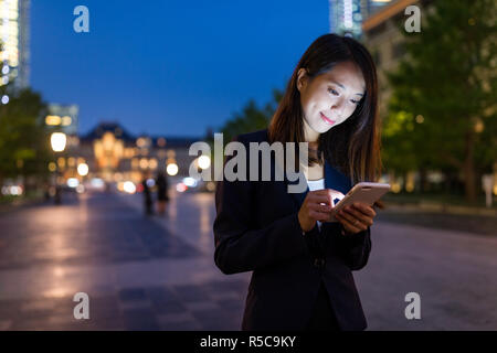 Jungen asiatischen Business woman mobile phone in Tokyo City Stockfoto