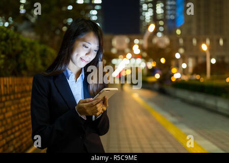 Geschäftsfrau mit Handy in Tokyo City bei Nacht Stockfoto