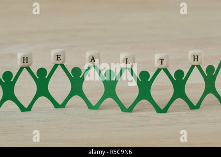 Papier Menschen Kette holding Gesundheit text auf Holz Würfel geschrieben Stockfoto