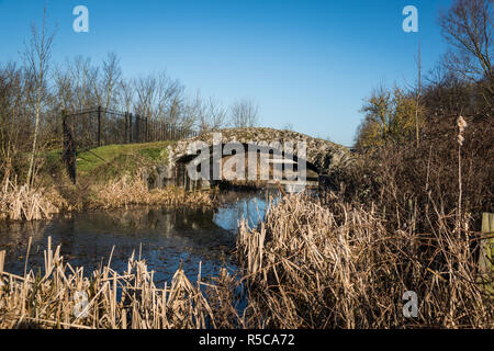 "Haralds Bridge" eine alte Steinbrücke über Cornmill Stream in den Abteigärten in Waltham Abbey, Essex, Großbritannien Stockfoto