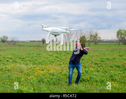 Ein Mann verbirgt sich eine Kollision mit einer Drohne. Quadrocopter Stockfoto