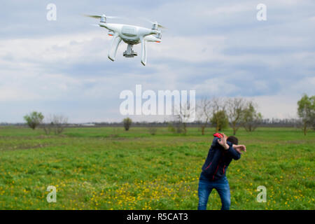 Ein Mann verbirgt sich eine Kollision mit einer Drohne. Quadrocopter Stockfoto