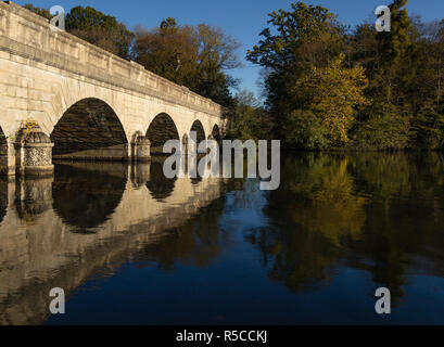 Gewölbte Brücke über Wasser, Reflexionen im Herbst Virginia Water Stockfoto