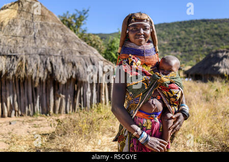 Porträt einer Muila Frau mit traditionellen Ornamenten und Frisur tragen ein Kind. Stockfoto