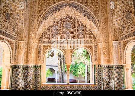 Maurische Architektur in der nasriden Paläste der Alhambra von Granada in Spanien, mit schönen aufwendigen Schnitzereien und Windows ovrlooking einen Garten. Stockfoto