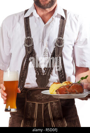 Mann in Leder hose mit Schweinebraten Stockfoto