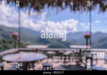 Blurry Terrace Cafe Tische und Stühle mit Bergblick Hintergrund Stockfoto