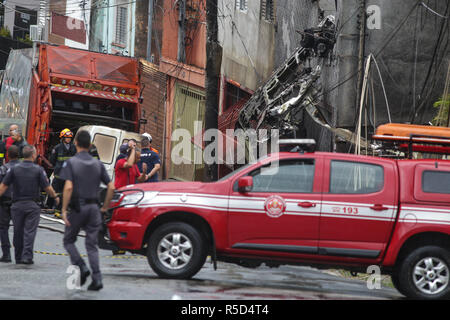 Sao Paulo, Brasilien. 30 Nov, 2018. Feuerwehrmänner arbeiten an einem Ort, wo ein kleines Flugzeug am Freitag Nachmittag abgestürzt, in der Nähe von Camp de Marte, im Norden von Sao Paulo. Das Flugzeug, eine Cessna 210, stürzte über zwei Wohnungen kurz nachdem er nahm ab. Mindestens zwei Menschen wurden getötet und 12 weitere verletzt. Credit: Dario Oliveira/ZUMA Draht/Alamy leben Nachrichten Stockfoto