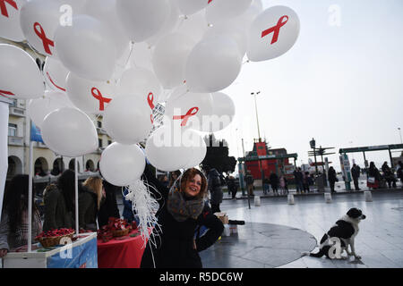 Thessaloniki, Griechenland. 1. Dez, 2018. Eine womanl hält Luftballons mit dem Red Ribbon Symbol auf Ihnen. Das Griechische Zentrum für die Prävention und die Kontrolle von Krankheiten organisiert eine informative Veranstaltung zum Welt-AIDS-Tag 2018, um das Bewusstsein für die AIDS-Pandemie durch die Ausbreitung der HIV-Infektion zu erhöhen. Credit: Giannis Papanikos/ZUMA Draht/Alamy leben Nachrichten Stockfoto