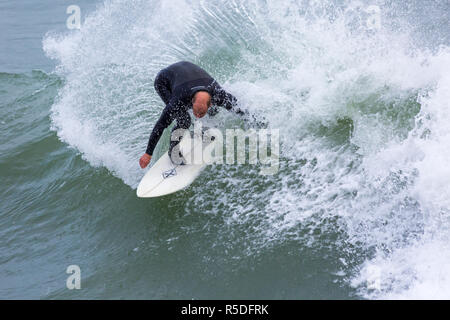 Bournemouth, Dorset, Großbritannien. 1. Dezember 2018. Surfer an der Küste der großen Wellen surfen am Strand von Bournemouth. In Aktion auf Surfbrett Reiten die Wellen Surfer. Credit: Carolyn Jenkins/Alamy leben Nachrichten Stockfoto