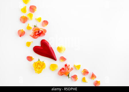 Rote Herzen, Rosen und Rosenblätter, auf weißem Hintergrund. Stockfoto