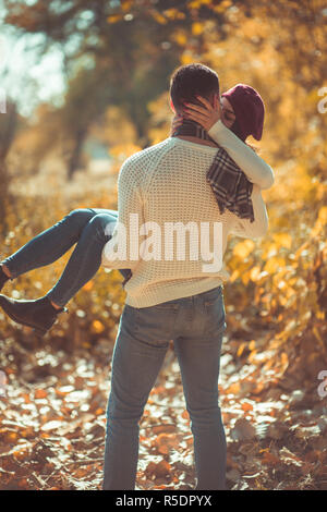 Verliebte Paar ist im Park, der Kerl ist mit ihrer Freundin, sie küssen und umarmen Stockfoto