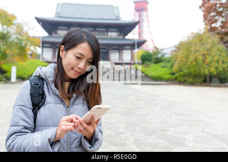 Frau, die Nutzung von Mobiltelefonen in Tokyo City Stockfoto