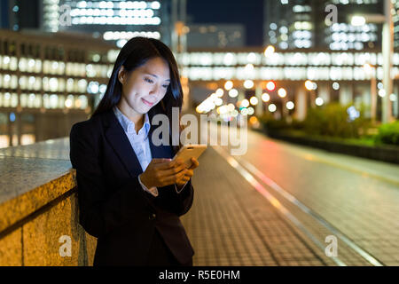 Business woman Gebrauch von Handys in der Stadt Tokio bei Nacht Stockfoto