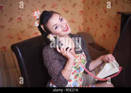 Schöne Frau Hausfrau in Schürze spricht per Telefon. Retro Style, Pin-up. Stockfoto