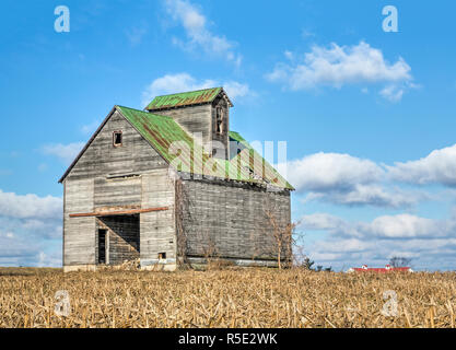 Eine rustikale alte Scheune steht dramatisch gegen einen bewölkten Himmel in einem ländlichen Ohio cornfield. Stockfoto