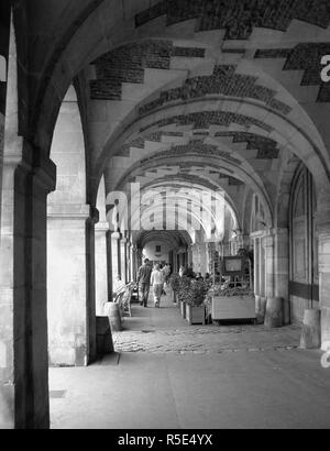 Place des Vosges, Le Marais, Paris, Frankreich: unter den Arkaden auf der Arcade. Schwarz und Weiss Stockfoto