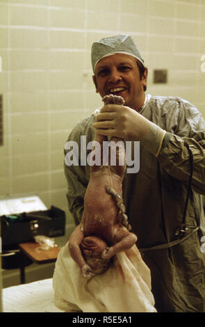 Ein Arzt hält ein Neugeborenes Baby bald nach der Kaiserschnitt in Union Hospital in New Ulm, Minnesota Ca. 1975 Stockfoto