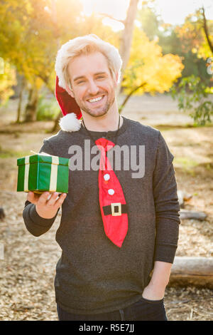 Schöne Festliche jungen kaukasischen Mann mit Geschenk im Freien. Stockfoto