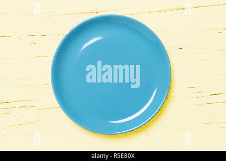 Blau pastellfarbenen Platte auf hellen gelben Holz- Hintergrund, Blick direkt von oben Stockfoto