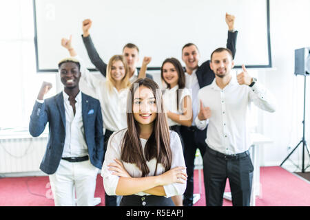 Portrait von LÄCHELNDEN asiatischen Geschäftsfrau vor vielfältigen Business Team. Stockfoto