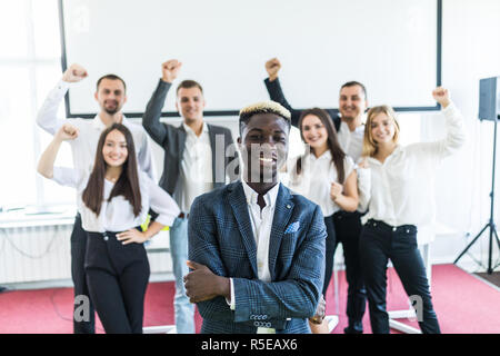 Schönen afrikanischen Geschäftsmann mit einer Gruppe von Geschäftsleuten auf Hintergrund Stockfoto