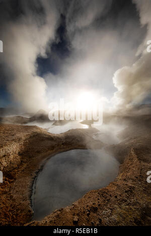 Die aufgehende Sonne durch die dampfende Pools im Sol de Mañana geothermischen Feld Stockfoto