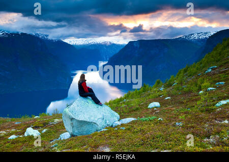 Ein einsamer Wanderer in den atemberaubenden Ausblick von einer Kurve in die dramatische Aurlands Aurlands Fjord, Fjord Sogn und Fjordane, Norwegen (MR) Stockfoto