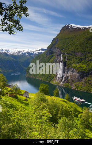 Eine Autofähre unter einem alten, verlassenen Hof & die Sieben Schwestern Wasserfall, Geiranger Fjord, Geiranger, Mehr og Romsdal, Norwegen Stockfoto
