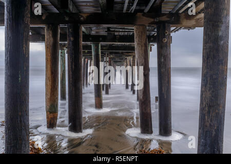 Unter Capitola Wharf in der Abenddämmerung. Stockfoto