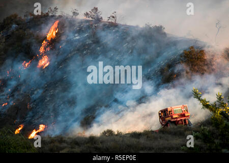 Wildfire Flammen brennen Hang Bürste mit dramatischen Formen und Farbe in der Kalifornischen Woolsey Feuer. Bulldozer im Vordergrund während der schusswechsel. Stockfoto